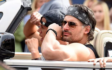 Channing Tatum and Joe Manganiello display muscular biceps on the set of a "Magic Mike" sequel, sitting in a convertible.