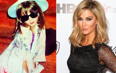 Child in sunglasses and hat next to adult woman with blonde hair in black dress posing on a red carpet.