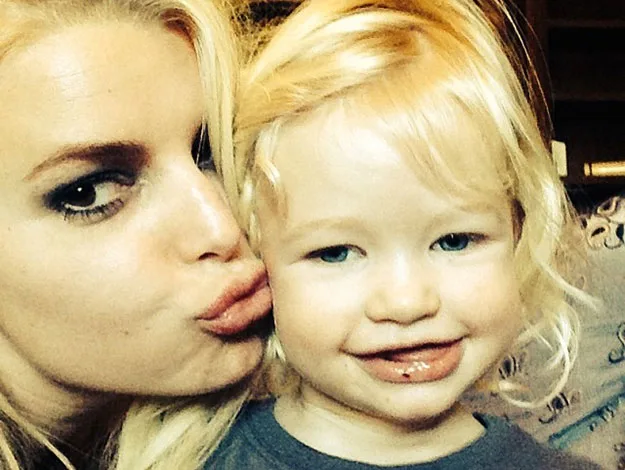 A woman with blonde hair pouts for a selfie with a smiling blonde-haired child.