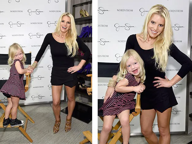 Woman in a black outfit posing with a young girl in a striped dress at a Nordstrom event.