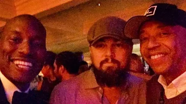 Men posing together at a party or event, smiling for the camera.