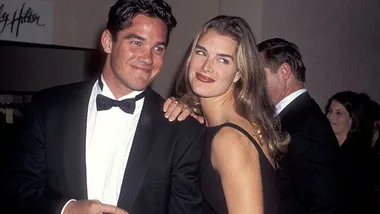 Two people dressed formally, smiling and posing at an event.