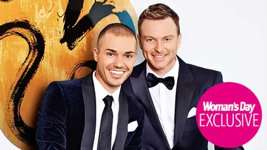 Two men in formal wear smiling in front of an abstract background; "Woman's Day Exclusive" label visible.