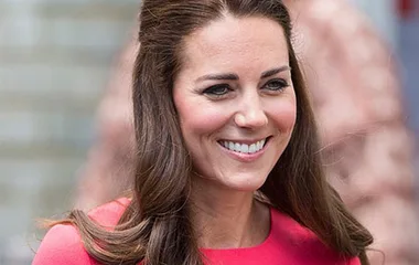 Smiling woman with long hair wearing a pink dress.