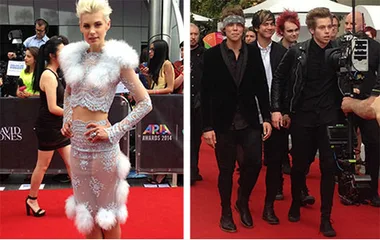 Australian celebrities on the red carpet at the 2014 ARIA Awards, featuring a singer in a fur-trimmed outfit and a band.