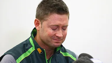 Michael Clarke emotional, wearing a green sports jacket, eyes closed, appearing to hold back tears during a press conference.