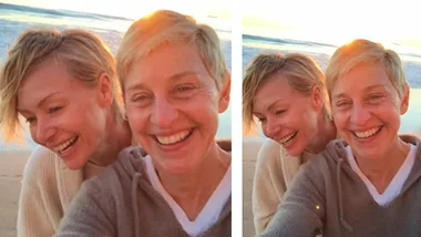 Two people smiling on a beach with the ocean and setting sun in the background.