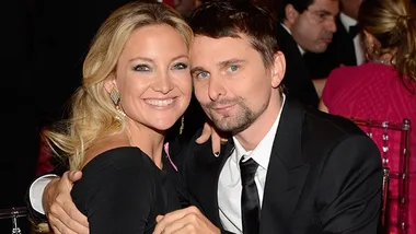 Kate Hudson and Matt Bellamy smiling at an event, dressed in formal wear.
