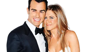Couple posing together at a formal event, with the man in a tuxedo and the woman in a white dress, both smiling.