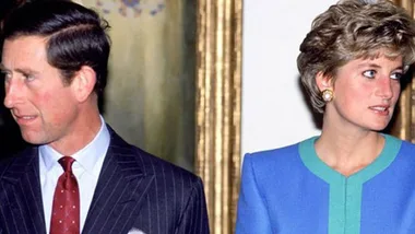 Prince Charles and Princess Diana standing apart, looking in opposite directions, both appearing thoughtful and serious.