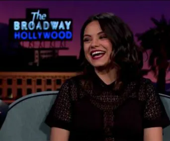 Person smiling on a talk show set with a "The Broadway Hollywood" sign in the background.