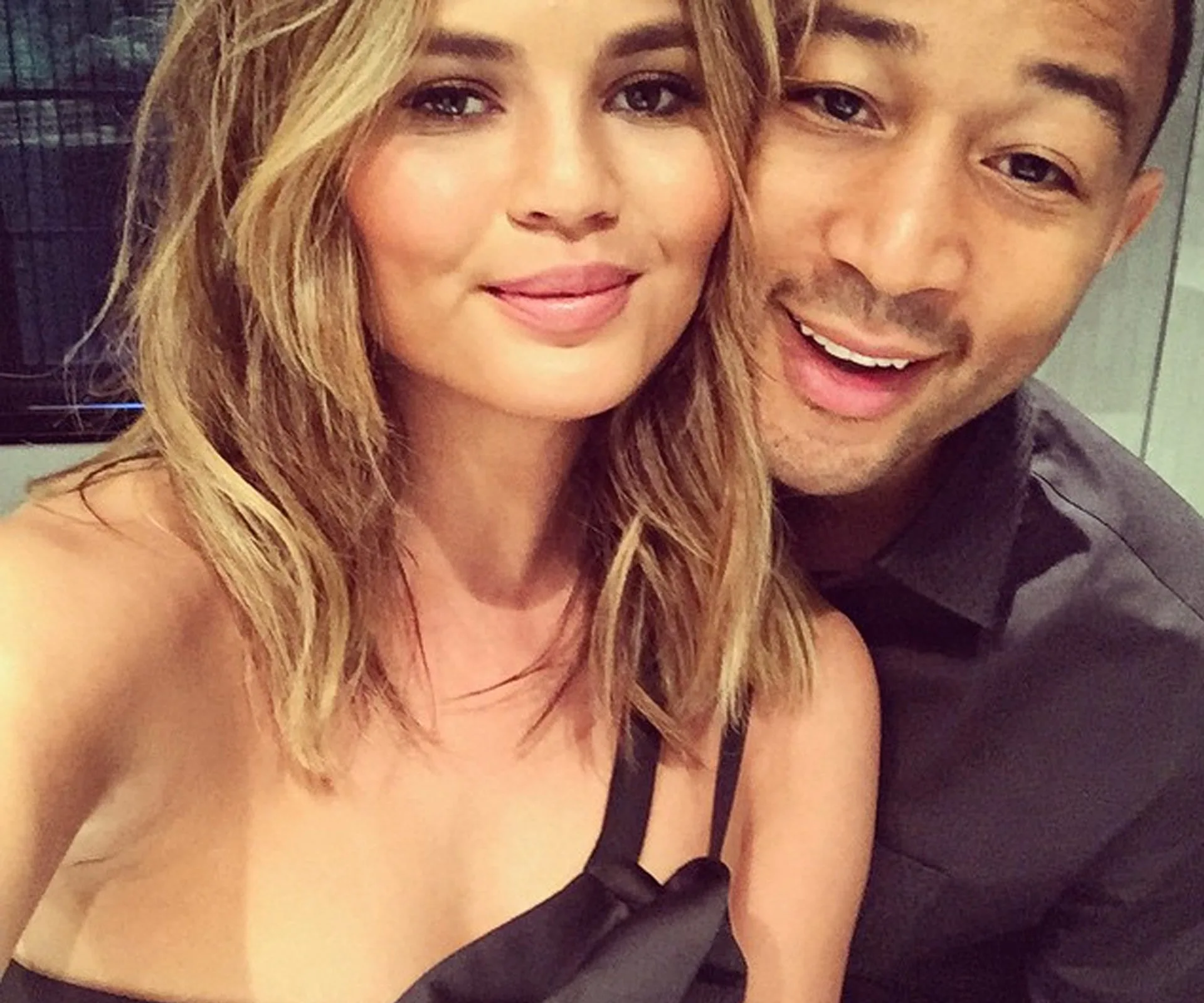 Couple smiling for a selfie, both in casual attire, with a close-up view.