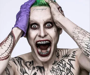 Jared Leto as the Joker with green hair, tattoos, and a manic expression from "Suicide Squad."