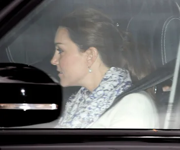 A woman with a ponytail, wearing a patterned scarf, seated in a car.