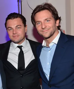 Two men in suits smiling and posing together at a party in New York.