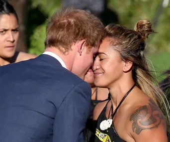 Prince Harry receives a traditional Maori greeting, Hongi, in New Zealand, touching noses with a Maori woman.