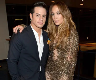 Two people posing elegantly for a photo at an event, one in a suit and the other in a sparkly evening gown.