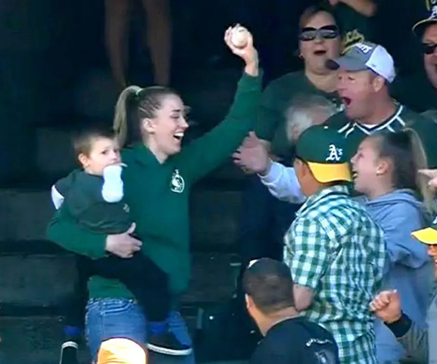 Multitasking Mom Baseball Mum holding her baby catches baseball with one hand!