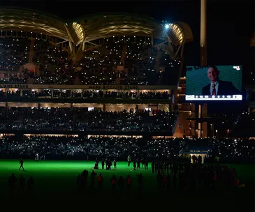 Ceremony at Adelaide Oval with crowd lights and a large screen tribute to Phil Walsh.