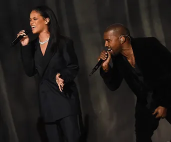 Rihanna and another artist performing on stage with microphones.