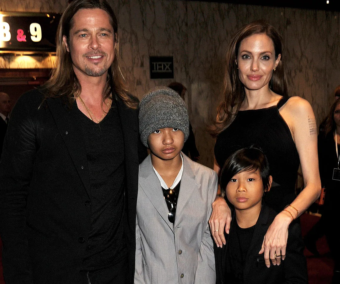 Family photo in formal attire at a movie theater event, smiling in front of theater signs.