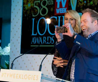 Two people on stage, smiling and taking a selfie at the 58th TV Week Logie Awards press event.