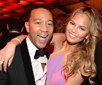 Two people smiling and embracing at an event, dressed in formal attire.
