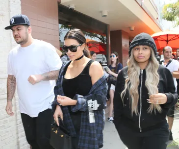 Rob Kardashian, Kim Kardashian, and Blac Chyna walking together casually in a public setting.