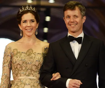Princess Mary of Denmark in an elegant gown and tiara, smiling alongside a man in a tuxedo.