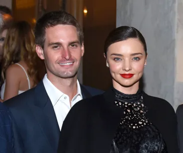 A man and a woman dressed formally, smiling at an event.