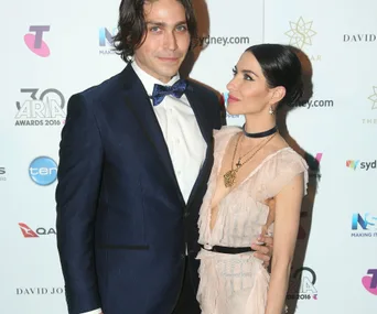 A man and woman pose on the red carpet at the ARIA Awards 2016; she looks at him affectionately.