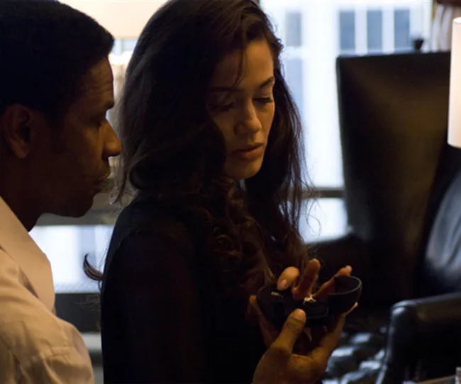 Man and woman examining a ring in a dimly lit room.