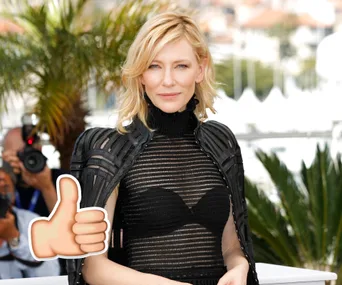 A person in a stylish black outfit poses outdoors with palm trees in the background, while a thumbs-up emoji is seen.