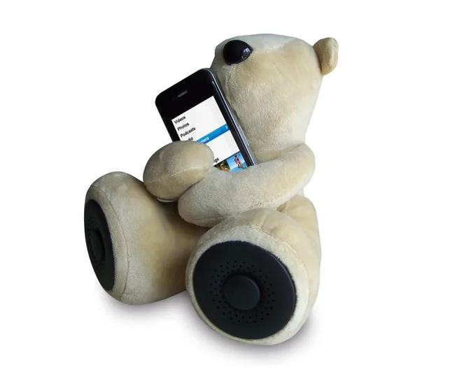 Teddy bear holding a smartphone displaying a media screen, speakers in its feet.