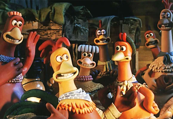 Claymation chickens from "Chicken Run" look surprised inside a barn, with varied expressions and outfits.