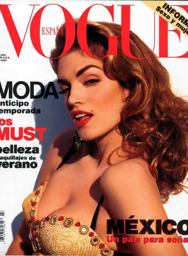 Cover of Vogue España featuring a woman with long hair and a glamorous pose, wearing a decorated top.