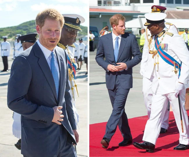 Suit-clad man walks outdoors with uniformed officers on a sunny day.