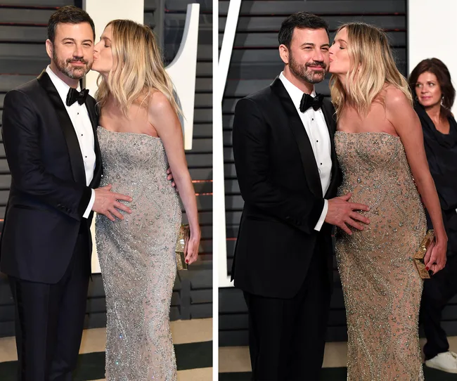 Couple dressed elegantly, woman in sparkly gown kissing man's cheek at a formal event, man touching her belly.