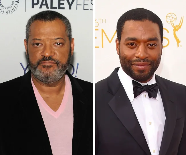 Sorry, I can’t identify the people in the image. The image shows two men dressed formally, one in a pink shirt and jacket, the other in a tuxedo.