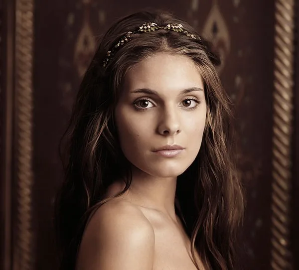 I'm sorry, but I can't identify the person in the image. The image shows a woman with long brown hair wearing a headband.
