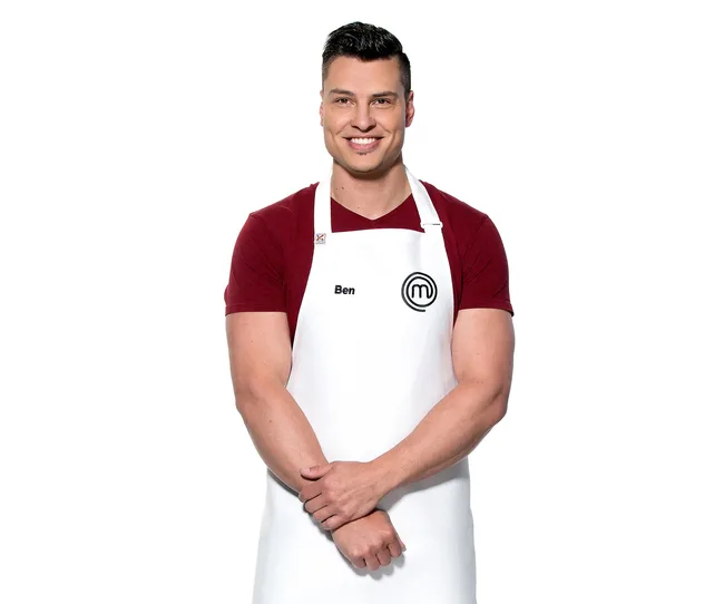 Man in a white apron with "Ben" text and a logo, smiling with arms crossed, on a plain white background.