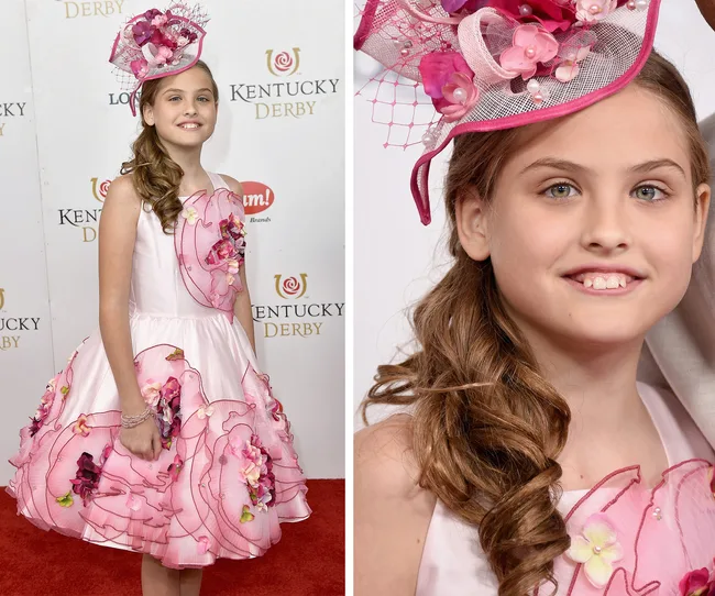 Girl in a pink floral dress and hat at the Kentucky Derby red carpet event.
