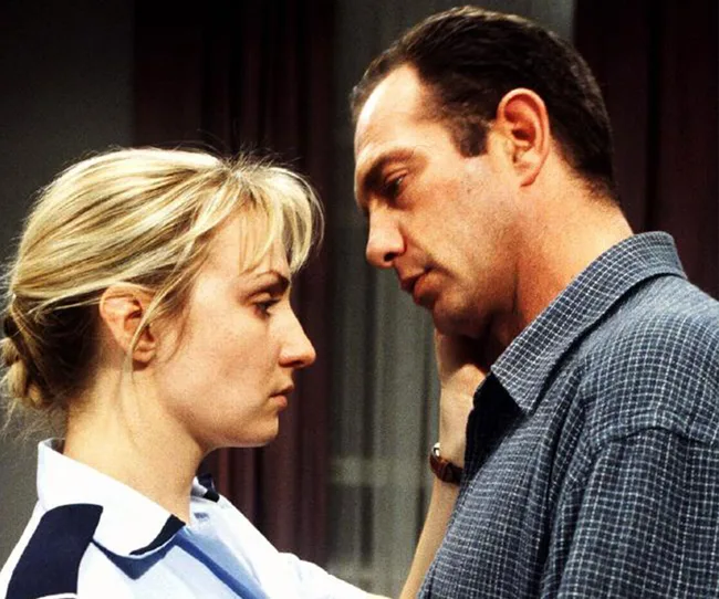 Man and woman in deep conversation, facing each other closely.
