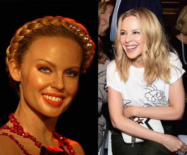 A wax statue wearing a braided updo and red necklace next to a smiling woman with blonde hair in a white shirt.