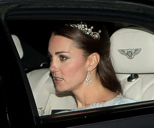 Kate Middleton wearing a tiara and earrings, seated in a car.