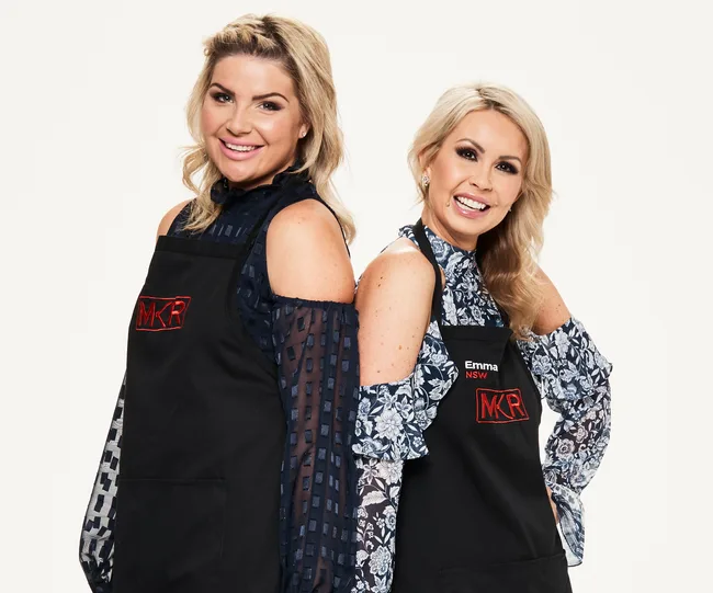 Two women in black "MKR" aprons, smiling.