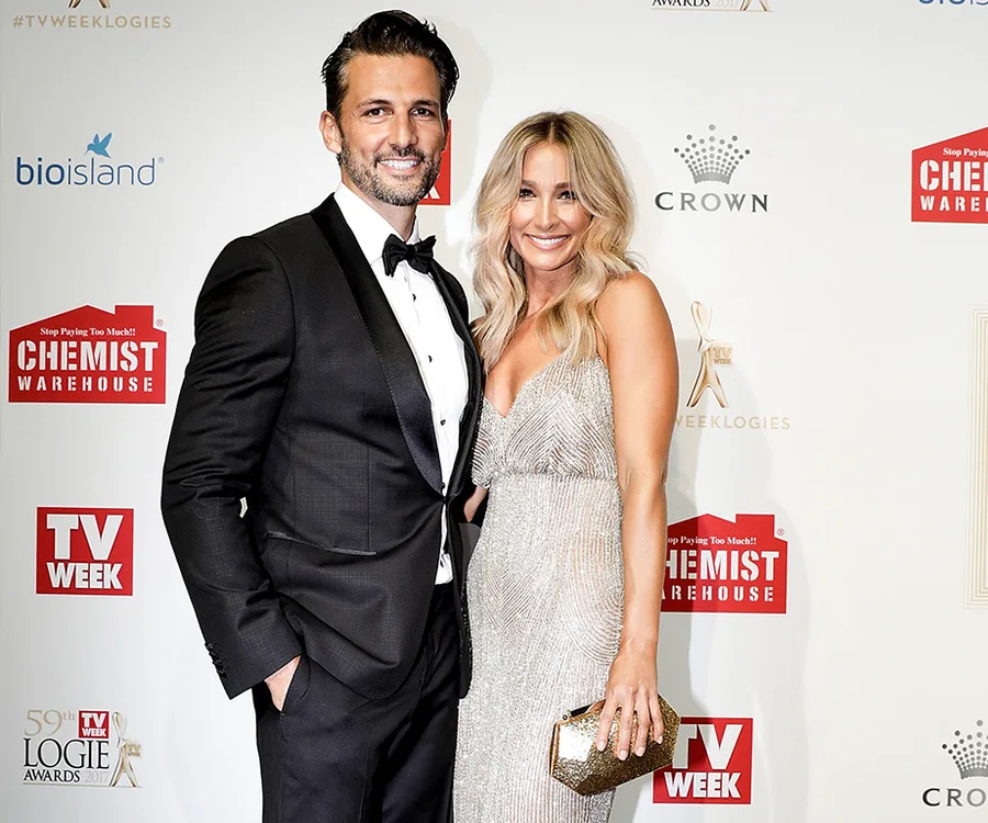 A couple posing elegantly on the red carpet at the TV WEEK Logie Awards, with a logo backdrop behind them.