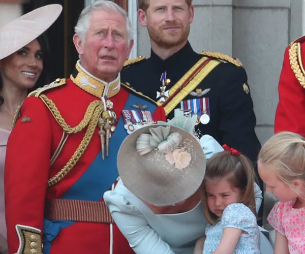 A formal gathering with military uniforms, a woman comforts a child, others observe, likely a ceremonial event.