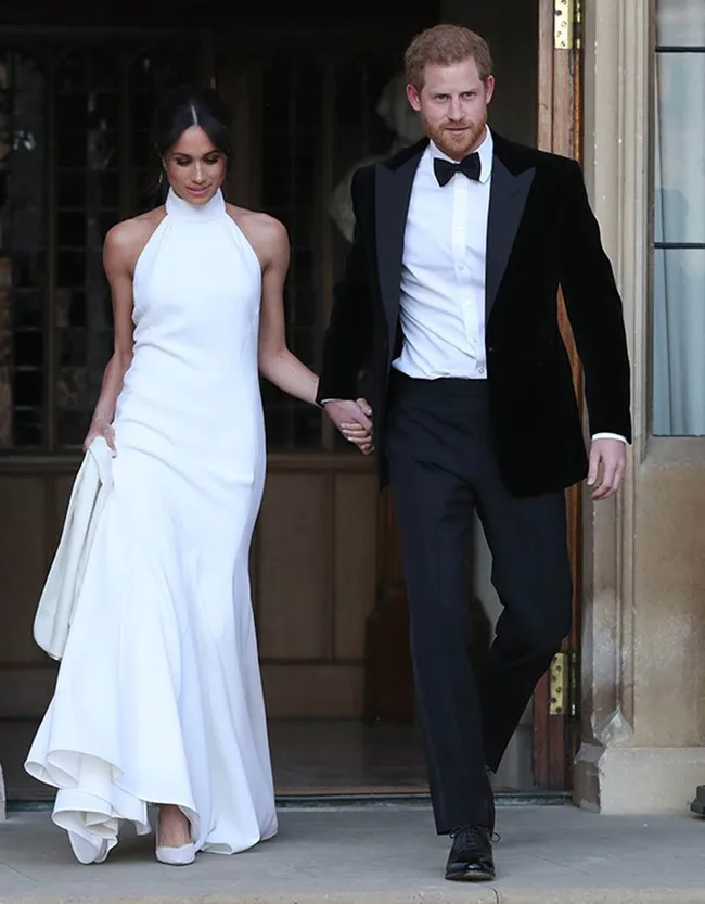 Couple in formal attire holding hands; the woman in a white gown and the man in a black tuxedo.