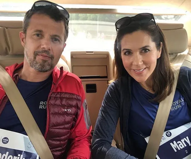 Two people sitting in a car, both wearing "Royal Run" shirts and sunglasses.
